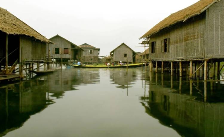 A row of houses on stilts in the water.