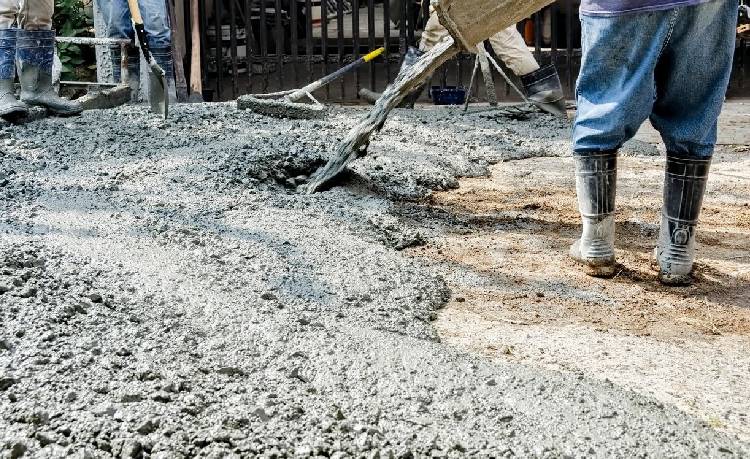 A man pouring cement onto a construction area