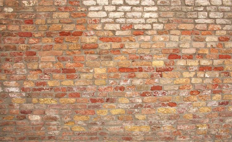 A brick wall with some type of graffiti on it