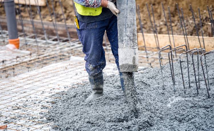 A man pouring cement onto a construction area